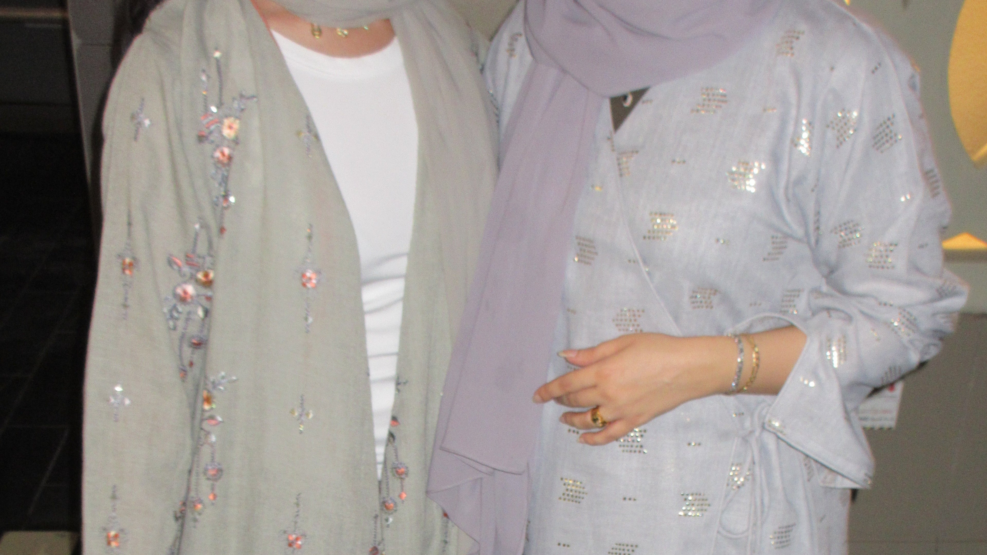Two friends wearing beautiful fancy abayas